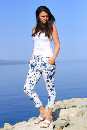 Unusual white sweatpants with a pattern of blue flowers. gray knit with drawstring to adjust the waist circumference 2