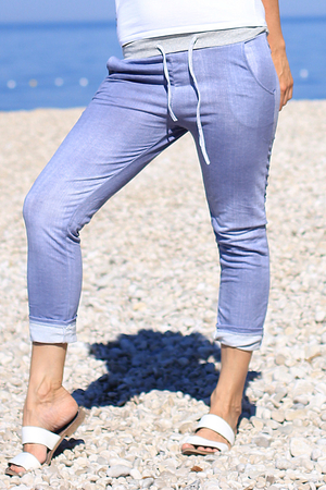 One-color blue women's sweatpants in 7/8 length. ribbed gray knit at the waist with elastic elastic and drawstring 2 side